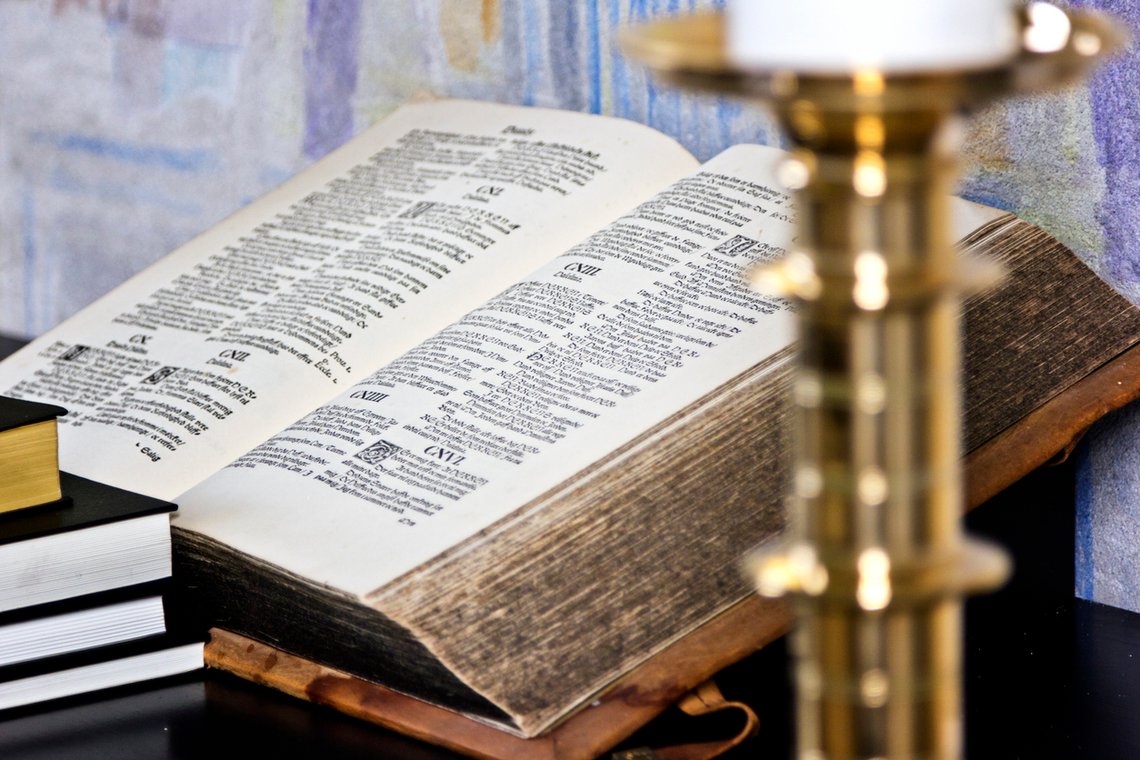 bible and candle holder on the altar of a danish village church bible and candle holder on the altar of a danish village church