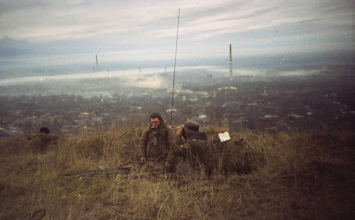 Russian soldiers, one of them wearing a WW2 German helmet, overlooking Grozny, 1999. Russian soldiers, one of them wearing a WW2 German helmet, overlooking Grozny, 1999.