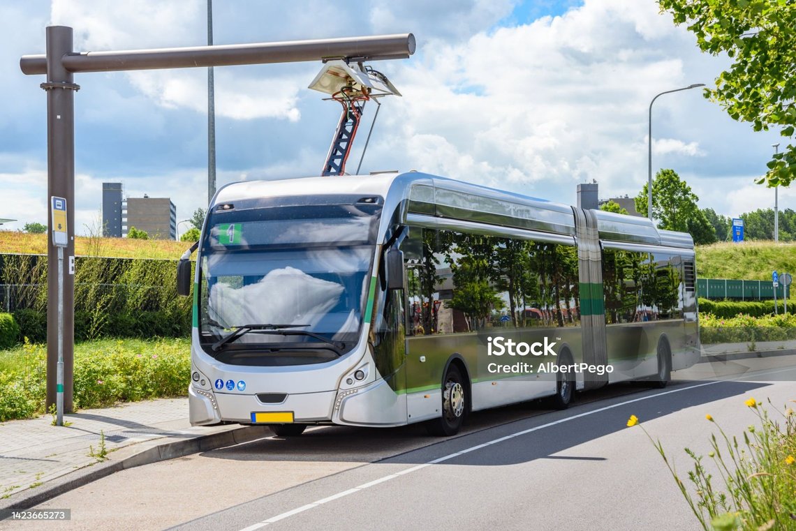 Photo of an electric city bus at a charging station on a sunny summer day. Concept of sustainable means of transport. Groningen, Netherlands. Photo of an electric city bus at a charging station on a sunny summer day. Concept of sustainable means of transport. Groningen, Netherlands.