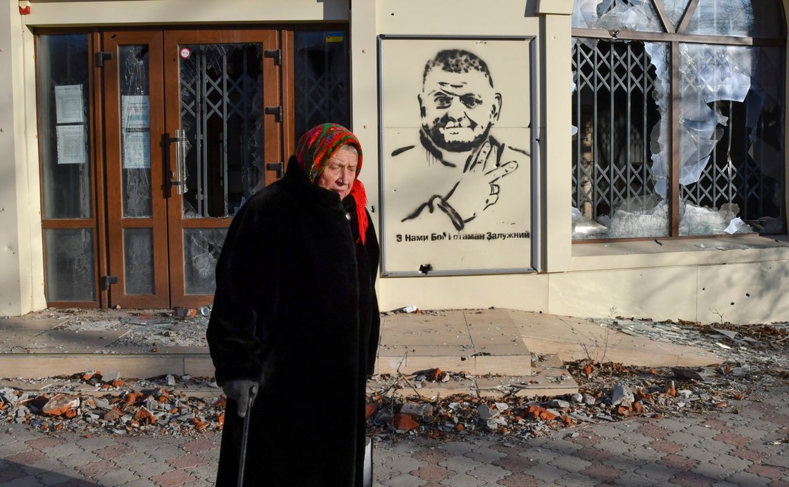 CAPTION CORRECTS TRANSLATION An elderly woman walks along a street against background of a graffiti depicting General Valery Zaluzhny, head of Ukraine's armed forces and writing ""God is with us and commander Zaluzhny" in the area of the heaviest battles with the Russian invaders in Bakhmut, Ukraine, Tuesday, Dec. 20, 2022. (AP Photo/Andriy Andriyenko) CAPTION CORRECTS TRANSLATION An elderly woman walks along a street against background of a graffiti depicting General Valery Zaluzhny, head of Ukraine's armed forces and writing ""God is with us and commander Zaluzhny" in the area of the heaviest battles with the Russian invaders in Bakhmut, Ukraine, Tuesday, Dec. 20, 2022. (AP Photo/Andriy Andriyenko)