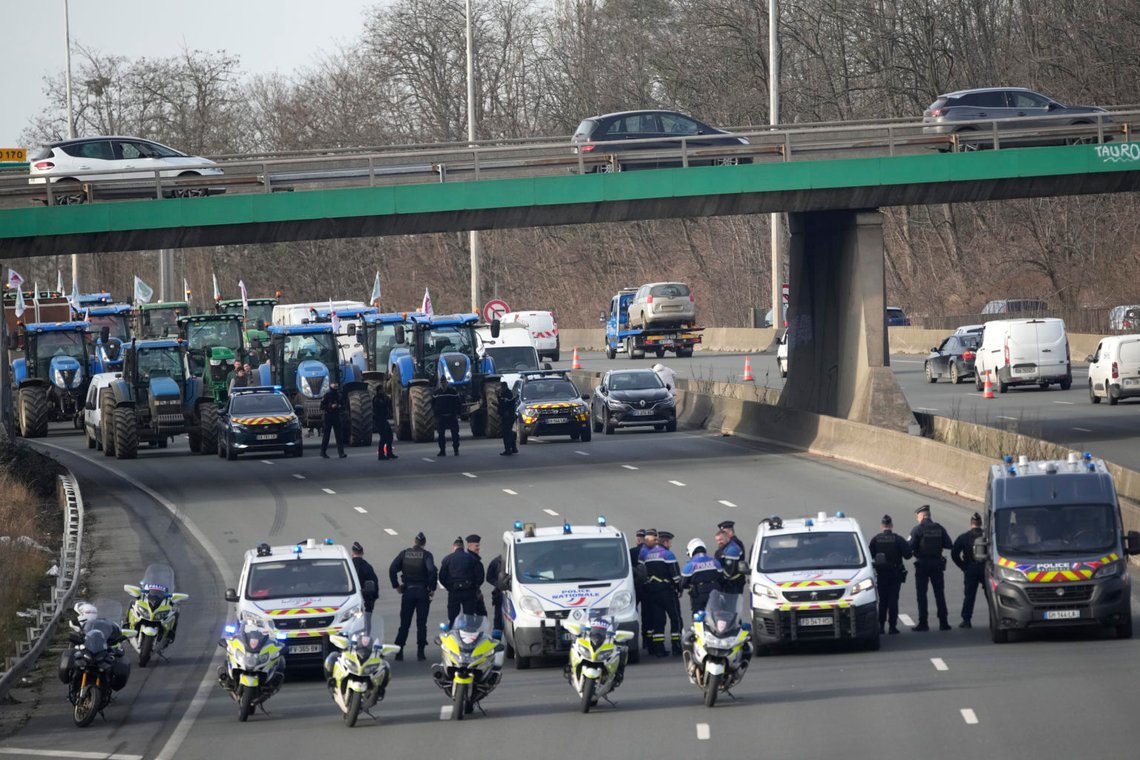 Police forces monitor a farmers demonstration on a highway, Monday, Jan. 29, 2024 in Argenteuil, north of Paris. Protesting farmers were encircling Paris with tractor barricades and drive-slows on Monday, using their lumbering vehicles to block highways leading to France's capital to pressure the government over the future of their industry, which has been shaken by repercussions of the Ukraine war. (AP Photo/Christophe Ena) Police forces monitor a farmers demonstration on a highway, Monday, Jan. 29, 2024 in Argenteuil, north of Paris. Protesting farmers were encircling Paris with tractor barricades and drive-slows on Monday, using their lumbering vehicles to block highways leading to France's capital to pressure the government over the future of their industry, which has been shaken by repercussions of the Ukraine war. (AP Photo/Christophe Ena)