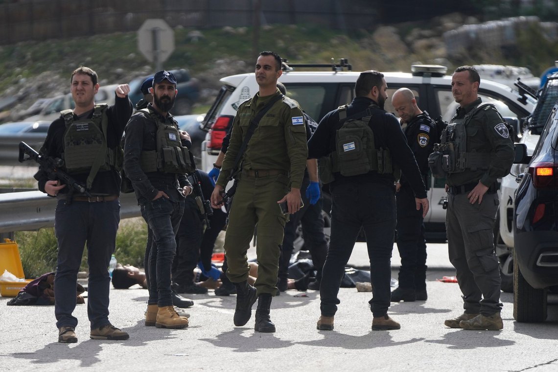 Israeli security forces examine the body of a Palestinian attacker outside the Israeli settlement of Maale Adumim, in the West Bank, Monday, Feb. 5, 2024. Israeli police say officers shot and killed a teenager who allegedly attempted to stab them in the occupied West Bank. (AP Photo/Mahmoud Illean) Israeli security forces examine the body of a Palestinian attacker outside the Israeli settlement of Maale Adumim, in the West Bank, Monday, Feb. 5, 2024. Israeli police say officers shot and killed a teenager who allegedly attempted to stab them in the occupied West Bank. (AP Photo/Mahmoud Illean)
