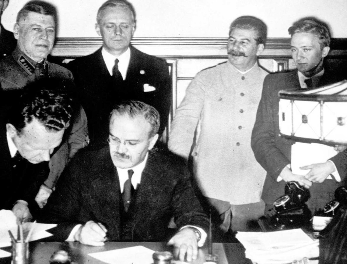 Soviet premier Josef Stalin (second from right), smiles while Soviet Foreign Minister Vyacheslav Molotov (seated), signs the non-aggression pact with German Reich Foreign Minister Joachim von Ribbentrop (third from right), in Moscow, on August 23, 1939. The man at left is Soviet Deputy Defense Minister and Chief of the General Staff, Marshal Boris Shaposhnikov. The nonaggression pact included a secret protocol dividing eastern Europe into spheres of influence in the event of a conflict. The pact now guaranteed that Hitler’s troops would face no resistance from the Soviets if they invaded Poland, bringing the war one step closer to reality. foto: Rarehistoricalphotos Soviet premier Josef Stalin (second from right), smiles while Soviet Foreign Minister Vyacheslav Molotov (seated), signs the non-aggression pact with German Reich Foreign Minister Joachim von Ribbentrop (third from right), in Moscow, on August 23, 1939. The man at left is Soviet Deputy Defense Minister and Chief of the General Staff, Marshal Boris Shaposhnikov. The nonaggression pact included a secret protocol dividing eastern Europe into spheres of influence in the event of a conflict. The pact now guaranteed that Hitler’s troops would face no resistance from the Soviets if they invaded Poland, bringing the war one step closer to reality. foto: Rarehistoricalphotos