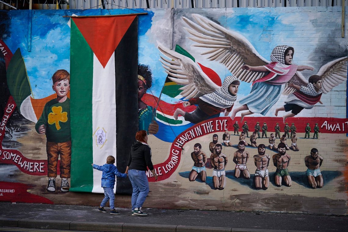 A woman and a child walk, during the unveiling of the International Wall after it was transformed into a Gaza mural, in Belfast, Sunday March 3, 2024. (Niall Carson/PA via AP) A woman and a child walk, during the unveiling of the International Wall after it was transformed into a Gaza mural, in Belfast, Sunday March 3, 2024. (Niall Carson/PA via AP)