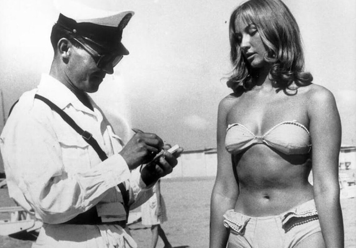 En politibetjent giver en kvinde en bøde for at bære bikini på en italiensk strand, 1957 En politibetjent giver en kvinde en bøde for at bære bikini på en italiensk strand, 1957