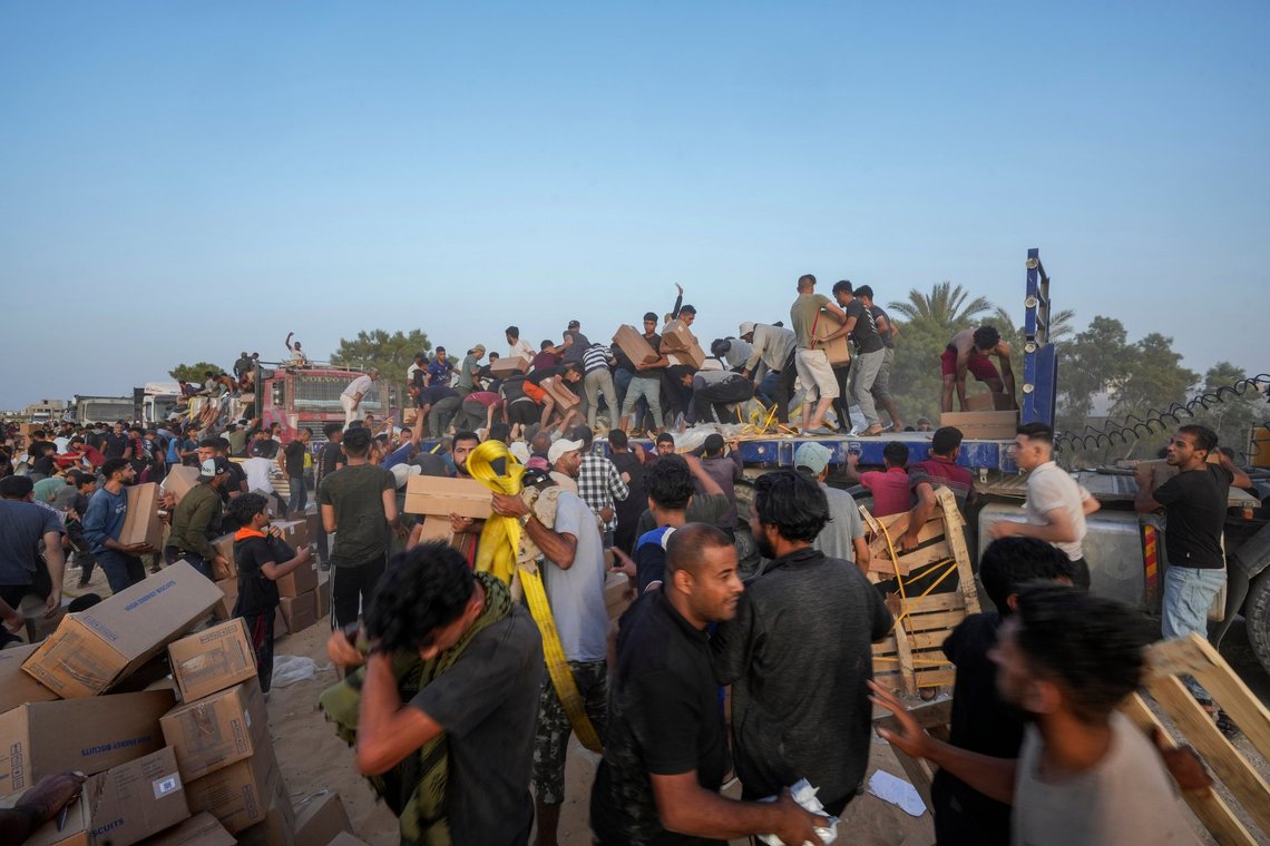 Palestinians are storming trucks loaded with humanitarian aid brought in through a new U.S.-built pier, in the central Gaza Strip, Saturday, May 18, 2024. (AP Photo/Abdel Kareem Hana) Palestinians are storming trucks loaded with humanitarian aid brought in through a new U.S.-built pier, in the central Gaza Strip, Saturday, May 18, 2024. (AP Photo/Abdel Kareem Hana)