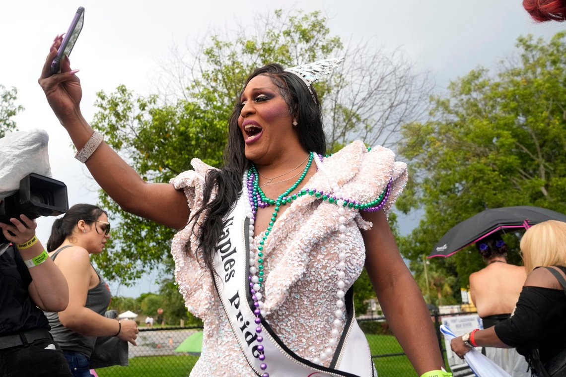 Drag queen og Miss Naples Pride Velvet Lenore fra West Palm Beach tager en selfie, mens hun kører på en vogn sponsoreret af flere transkønnede grupper under Stonewall Pride Parade and Street Festival, lørdag den 17. juni 2023, i Wilton Manors, Florida (AP Photo/Lynne Sladky). Drag queen og Miss Naples Pride Velvet Lenore fra West Palm Beach tager en selfie, mens hun kører på en vogn sponsoreret af flere transkønnede grupper under Stonewall Pride Parade and Street Festival, lørdag den 17. juni 2023, i Wilton Manors, Florida (AP Photo/Lynne Sladky).