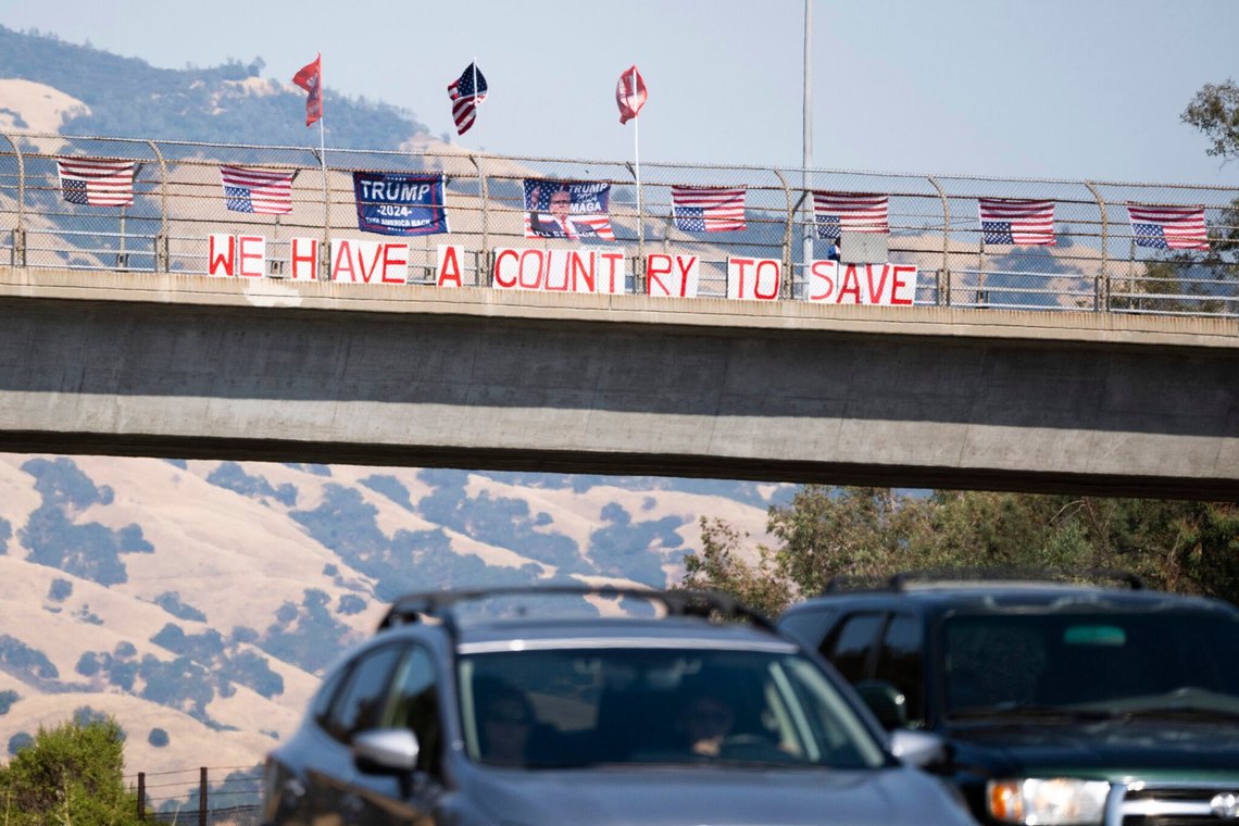 Flag, der støtter den republikanske præsidentkandidat, tidligere præsident Donald Trump, og amerikanske flag, der vender på hovedet, vajer på en overkørsel på Highway 24 i Lafayette, Californien, søndag den 14. juli 2024. (Minh Connors/San Francisco Chronicle via AP) Flag, der støtter den republikanske præsidentkandidat, tidligere præsident Donald Trump, og amerikanske flag, der vender på hovedet, vajer på en overkørsel på Highway 24 i Lafayette, Californien, søndag den 14. juli 2024. (Minh Connors/San Francisco Chronicle via AP)