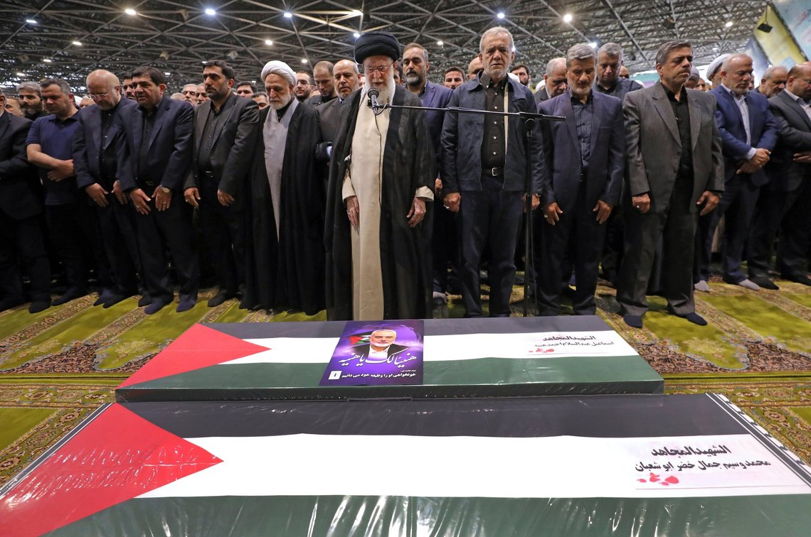 In this photo released by an official website of the office of the Iranian supreme leader, Supreme Leader Ayatollah Ali Khamenei, center, leads a prayer over the coffins of Hamas leader Ismail Haniyeh and his bodyguard who were killed in an assassination blamed on Israel on Wednesday, during their funeral ceremony at the Tehran University campus, in Tehran, Iran, Thursday, Aug. 1, 2024. Iranian President Masoud Pezeshkian prays at center right. (Office of the Iranian Supreme Leader via AP) In this photo released by an official website of the office of the Iranian supreme leader, Supreme Leader Ayatollah Ali Khamenei, center, leads a prayer over the coffins of Hamas leader Ismail Haniyeh and his bodyguard who were killed in an assassination blamed on Israel on Wednesday, during their funeral ceremony at the Tehran University campus, in Tehran, Iran, Thursday, Aug. 1, 2024. Iranian President Masoud Pezeshkian prays at center right. (Office of the Iranian Supreme Leader via AP)