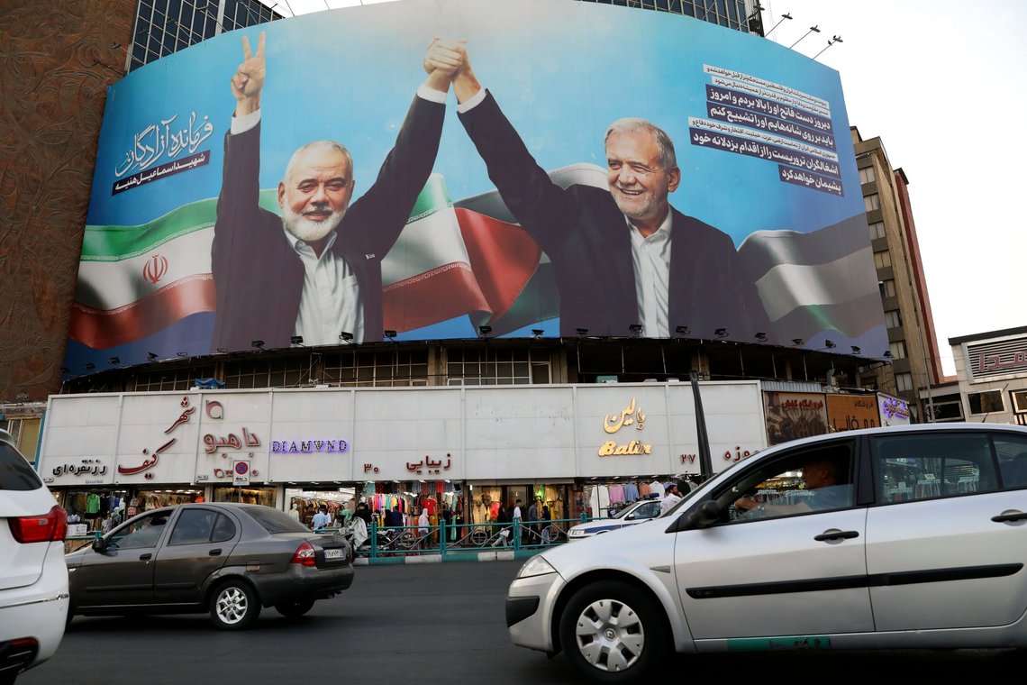 Vehicles drive past a huge banner showing the late Hamas leader Ismail Haniyeh, left, who was killed in an assassination last week, joining hands with Iranian President Masoud Pezeshkian, in a square in downtown Tehran, Iran, Monday, Aug. 5, 2024. Iran has vowed to respond with "power and decisiveness" to the targeted killing of Hamas' top political leader, which it blamed on Israel. (AP Photo/Vahid Salemi) Vehicles drive past a huge banner showing the late Hamas leader Ismail Haniyeh, left, who was killed in an assassination last week, joining hands with Iranian President Masoud Pezeshkian, in a square in downtown Tehran, Iran, Monday, Aug. 5, 2024. Iran has vowed to respond with "power and decisiveness" to the targeted killing of Hamas' top political leader, which it blamed on Israel. (AP Photo/Vahid Salemi)