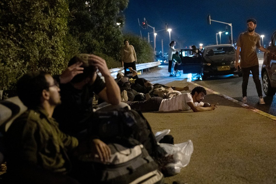 Israelis take cover as projectiles launched from Iran are being intercepted in the skies over in Rosh HaAyin, Israel, Tuesday, Oct. 1, 2024. (AP Photo/Maya Alleruzzo) Israelis take cover as projectiles launched from Iran are being intercepted in the skies over in Rosh HaAyin, Israel, Tuesday, Oct. 1, 2024. (AP Photo/Maya Alleruzzo)