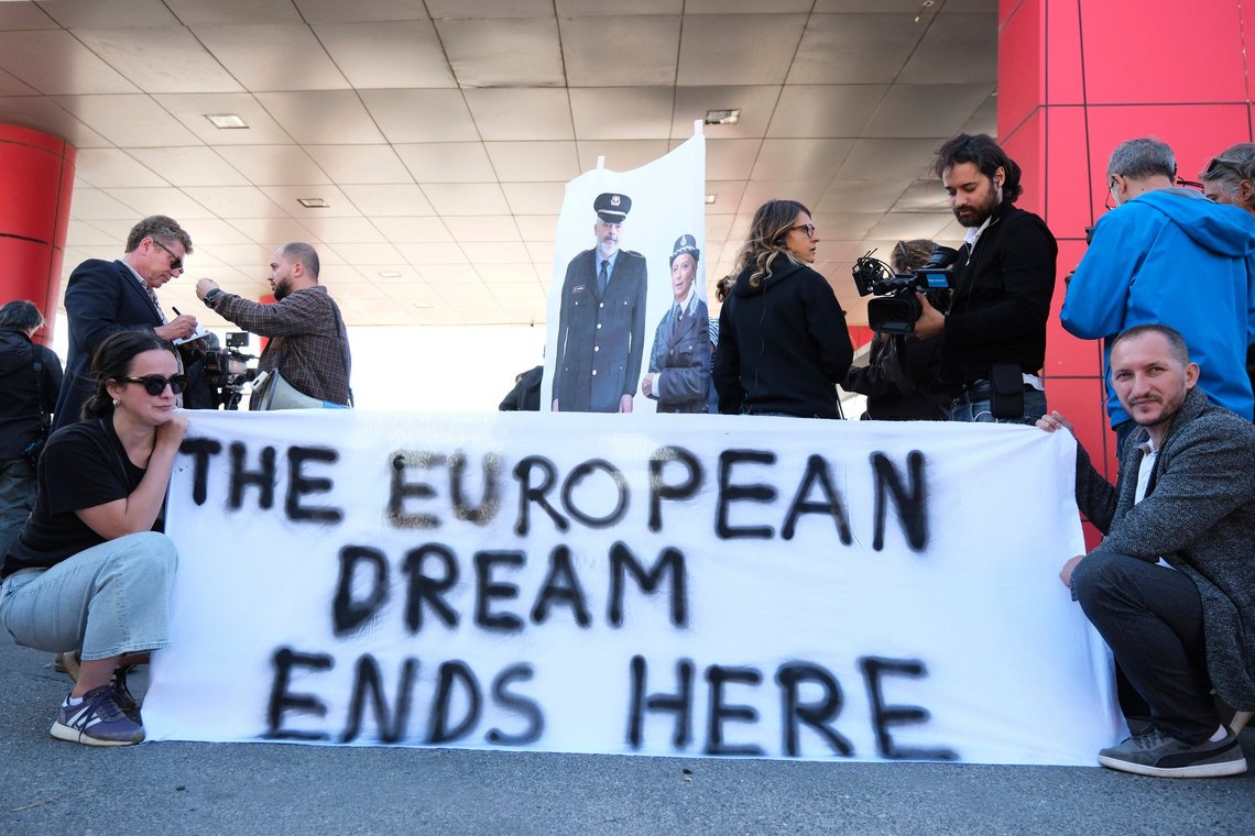 Activists, holding pictures of the Italian and Albanian premiers dressed as police officers, protest at the entrance of the port of Shengjin, northwestern Albania, Wednesday, Oct. 16, 2024, following the arrival of an Italian navy ship carrying the first group of migrants who were intercepted in international waters. (AP Photo/Vlasov Sulaj) Activists, holding pictures of the Italian and Albanian premiers dressed as police officers, protest at the entrance of the port of Shengjin, northwestern Albania, Wednesday, Oct. 16, 2024, following the arrival of an Italian navy ship carrying the first group of migrants who were intercepted in international waters. (AP Photo/Vlasov Sulaj)