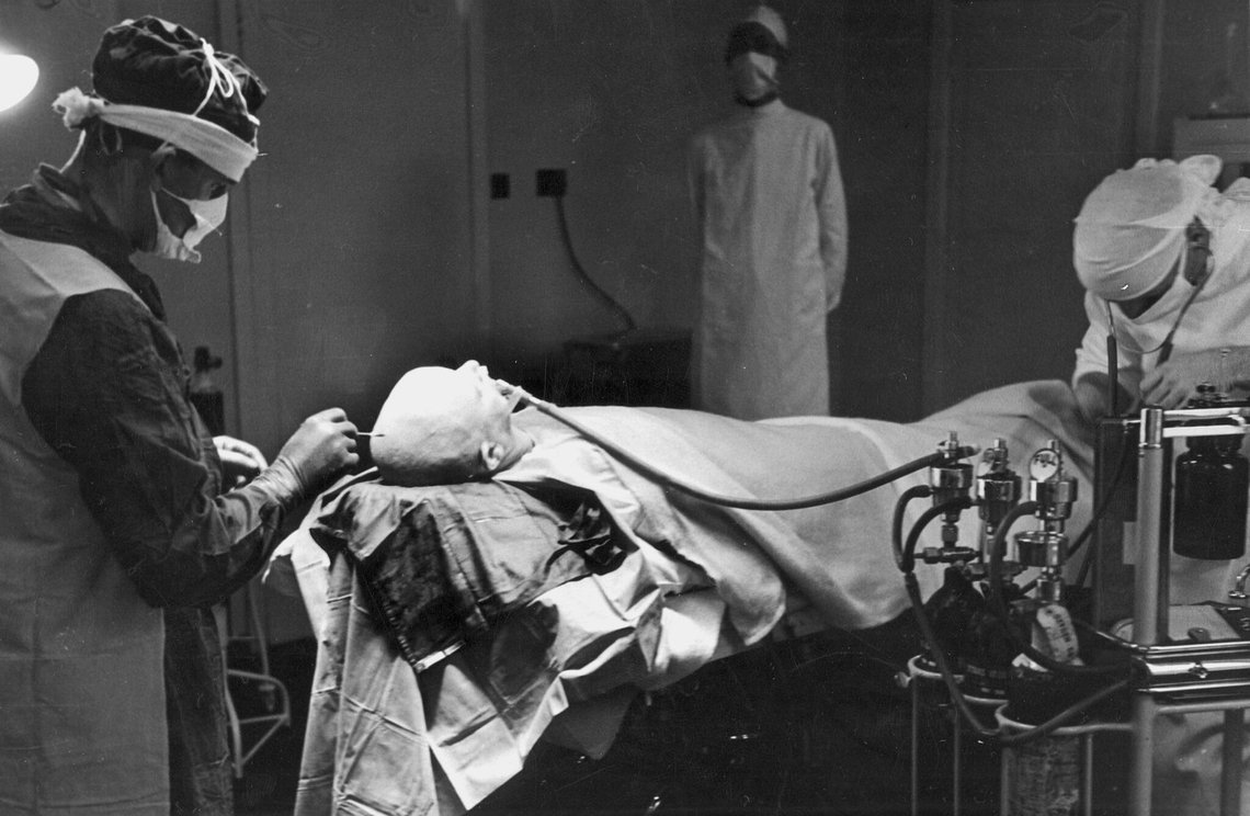 Forberedelse til en hjerneoperation på et engelsk sindssygehospital i 1947. »Hvis insulin og elektroterapi ikke kan bryde de ondartede forbindelser, er operationskniven det sidste håb.« Foto: R. Hutton / Aktuell / NTB. Forberedelse til en hjerneoperation på et engelsk sindssygehospital i 1947. »Hvis insulin og elektroterapi ikke kan bryde de ondartede forbindelser, er operationskniven det sidste håb.« Foto: R. Hutton / Aktuell / NTB.
