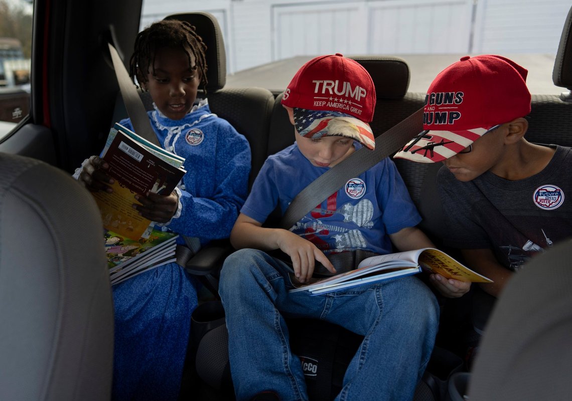 Gianna Young, 7, left, Isaac Young, 5, center, and Lucas Young, 8, look at books in the back seat of the truck for the trip to vote with adoptive parents Mike and Erin Young on Election Day, Tuesday, Nov. 5, 2024, in Sunbury, Ohio. (AP Photo/Carolyn Kaster) Gianna Young, 7, left, Isaac Young, 5, center, and Lucas Young, 8, look at books in the back seat of the truck for the trip to vote with adoptive parents Mike and Erin Young on Election Day, Tuesday, Nov. 5, 2024, in Sunbury, Ohio. (AP Photo/Carolyn Kaster)