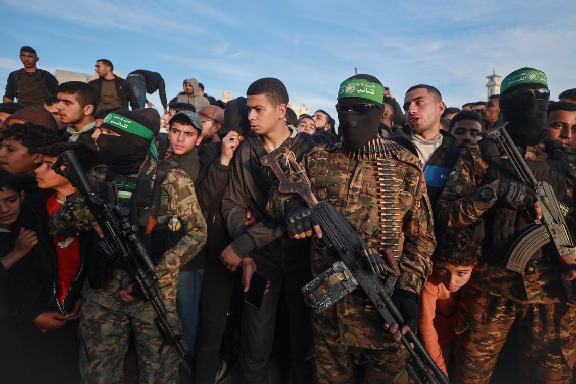 Fighters from the Qassam Brigades, the military wing of Hamas, control the crowd as Red Cross vehicles manoeuvre to collect Israeli hostages to be released under a ceasefire agreement between Israel and Hamas, in Gaza City, Sunday, Jan. 19, 2025. (AP Photo/Abed Hajjar) Fighters from the Qassam Brigades, the military wing of Hamas, control the crowd as Red Cross vehicles manoeuvre to collect Israeli hostages to be released under a ceasefire agreement between Israel and Hamas, in Gaza City, Sunday, Jan. 19, 2025. (AP Photo/Abed Hajjar)