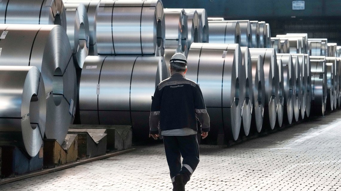En arbeider passerer forbi noen stålspoler ved Thyssenkrupps stålverk i Duisburg den 20. mars 2025. Foto: Martin Meissner / AP / NTB. En arbeider passerer forbi noen stålspoler ved Thyssenkrupps stålverk i Duisburg den 20. mars 2025. Foto: Martin Meissner / AP / NTB.