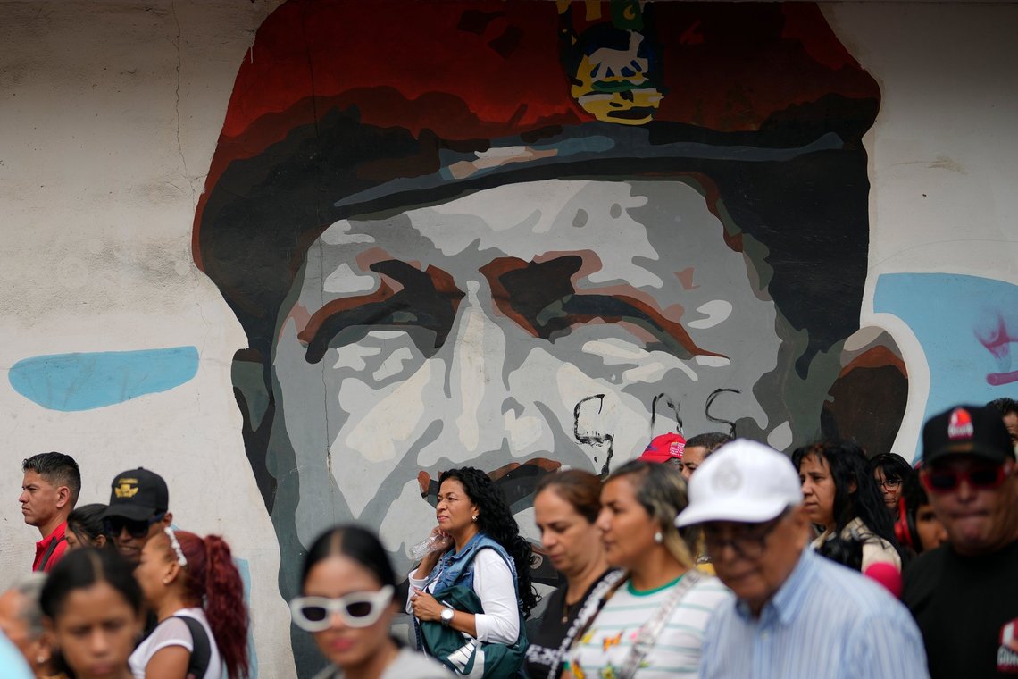 People march past a mural of late President Hugo Chavez in Caracas, Venezuela, Tuesday, March 18, 2025, during a government-organized rally to protest the deportation from the U.S. of alleged members of the Venezuelan Tren de Aragua gang, who were transferred to a prison in El Salvador. (AP Photo/Ariana Cubillos) People march past a mural of late President Hugo Chavez in Caracas, Venezuela, Tuesday, March 18, 2025, during a government-organized rally to protest the deportation from the U.S. of alleged members of the Venezuelan Tren de Aragua gang, who were transferred to a prison in El Salvador. (AP Photo/Ariana Cubillos)