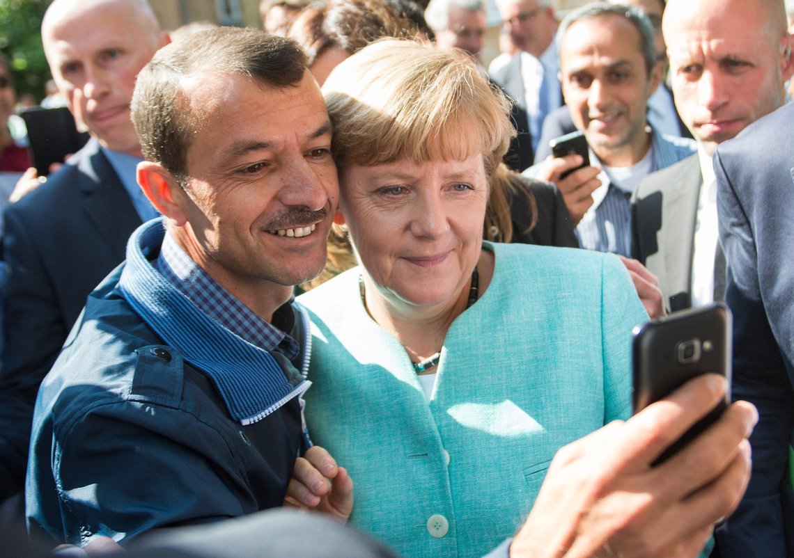 Den tyske kansler Angela Merkel tager en selfie med en asylansøger i et flygtningecenter i Berlin, Tyskland, den 10. september 2015. Mere end 1 million asylansøgere ankom til Tyskland. Foto: Bernd von Jutrczenka, AP-NTB. Den tyske kansler Angela Merkel tager en selfie med en asylansøger i et flygtningecenter i Berlin, Tyskland, den 10. september 2015. Mere end 1 million asylansøgere ankom til Tyskland. Foto: Bernd von Jutrczenka, AP-NTB.