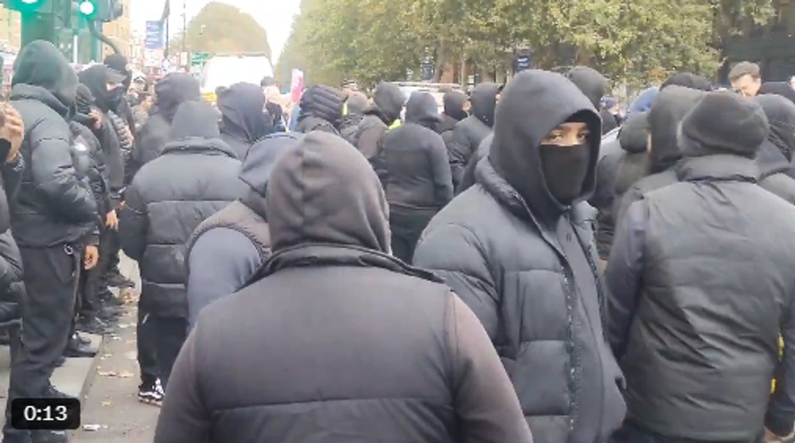 Maskede muslimer marcherede i Tower Hamlets og viftede med palæstinensiske flag. Stillbillede fra video Maskede muslimer marcherede i Tower Hamlets og viftede med palæstinensiske flag. Stillbillede fra video
