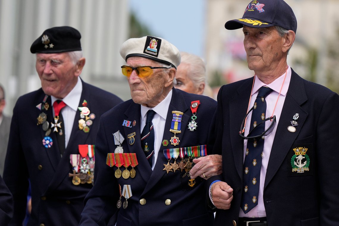 Alec Penstone, i midten, en tidligere Royal Navy-veteran, som gjorde tjeneste på eskortefartøjet HMS Campania, går sammen med andre D-dag-veteraner under en parade i Arromanches les-Bains i Normandiet, Frankrig, den 6. juni 2024. Foto: Alastair Grant, AP-NTB. Alec Penstone, i midten, en tidligere Royal Navy-veteran, som gjorde tjeneste på eskortefartøjet HMS Campania, går sammen med andre D-dag-veteraner under en parade i Arromanches les-Bains i Normandiet, Frankrig, den 6. juni 2024. Foto: Alastair Grant, AP-NTB.
