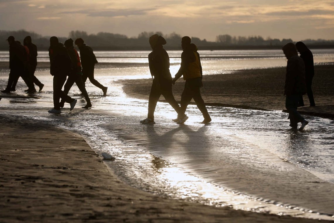 En gruppe migranter går væk fra stranden i Gravelines i det nordlige Frankrig efter et mislykket forsøg på at krydse Den Engelske Kanal den 6. november. Foto: Jean-François Badias/AP/NTB En gruppe migranter går væk fra stranden i Gravelines i det nordlige Frankrig efter et mislykket forsøg på at krydse Den Engelske Kanal den 6. november. Foto: Jean-François Badias/AP/NTB