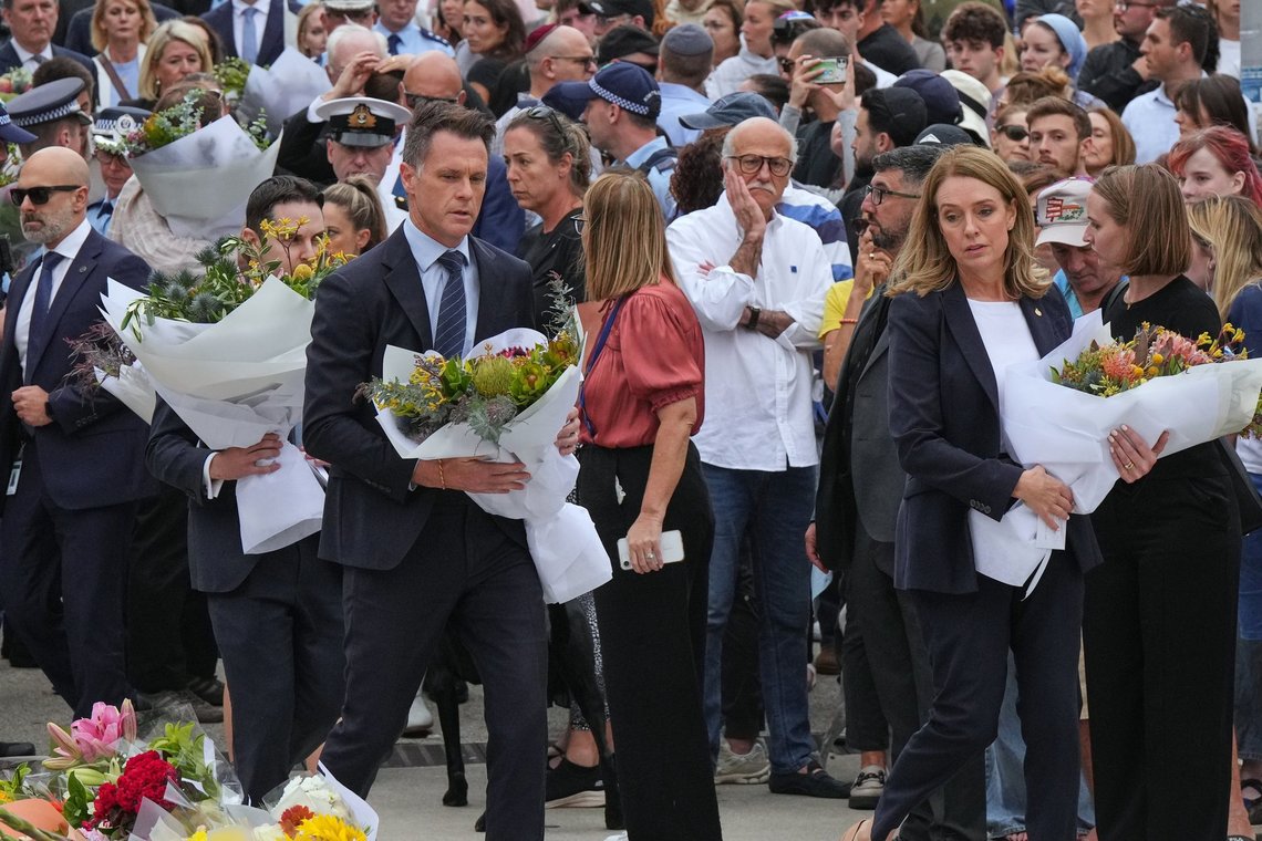 New South Wales' premierminister Chris Minns og oppositionsleder Kellie Sloane gør sig klar til at lægge kranse ved en mindehøjtidelighed for ofrene for terroren uden for Bondi Pavilion på Bondi Beach i Sydney mandag den 15. december 2025, dagen efter skyderiet. Foto: AP /Mark Baker/ NTB New South Wales' premierminister Chris Minns og oppositionsleder Kellie Sloane gør sig klar til at lægge kranse ved en mindehøjtidelighed for ofrene for terroren uden for Bondi Pavilion på Bondi Beach i Sydney mandag den 15. december 2025, dagen efter skyderiet. Foto: AP /Mark Baker/ NTB