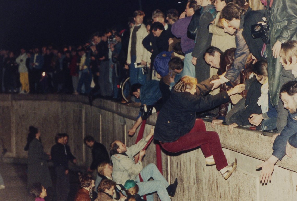 FILE - East Berliners get helping hands from West Berliners as they climb the Berlin Wall which has divided the city since the end of World War II, near the Brandenburger Tor (Branderburg Gate), early Friday morning, Nov. 10, 1989. (AP Photo/Jockel Finck, File) FILE - East Berliners get helping hands from West Berliners as they climb the Berlin Wall which has divided the city since the end of World War II, near the Brandenburger Tor (Branderburg Gate), early Friday morning, Nov. 10, 1989. (AP Photo/Jockel Finck, File)