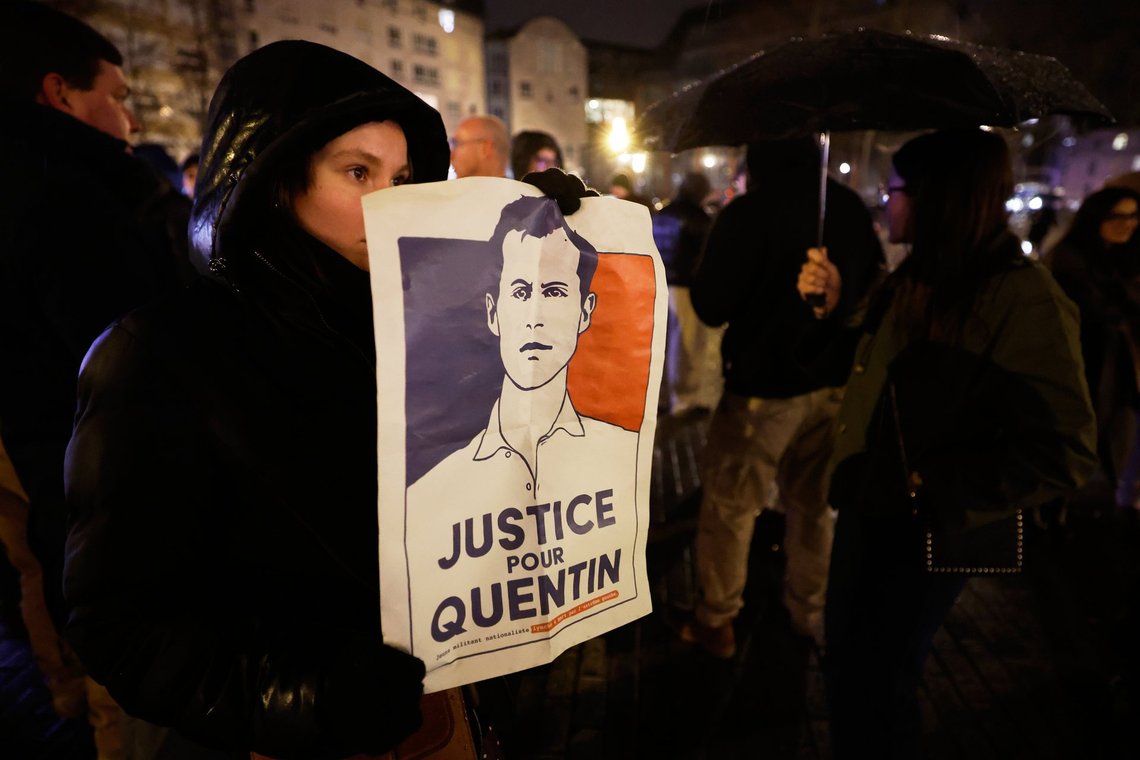 A woman holds a placard reading "Justice for Quentin" as she pays tribute to far-right student, Quentin Deranque, 23, who died in Lyon from a street beating during clashes between far-left and far-right militants, in Lille, northern France, Wednesday, Feb. 18, 2026. (AP Photo/Jean-Francois Badias) A woman holds a placard reading "Justice for Quentin" as she pays tribute to far-right student, Quentin Deranque, 23, who died in Lyon from a street beating during clashes between far-left and far-right militants, in Lille, northern France, Wednesday, Feb. 18, 2026. (AP Photo/Jean-Francois Badias)