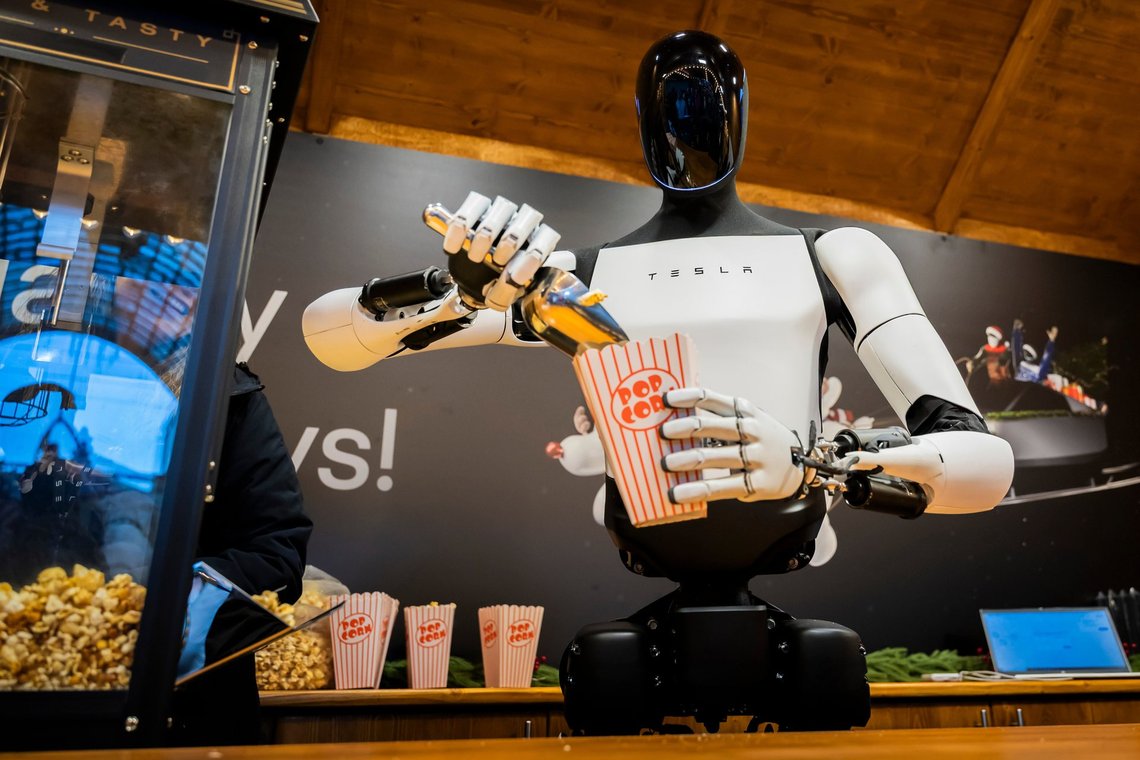 Tesla's humanoid robot 'Optimus' distributes popcorn at a Christmas market stall during its presentation at a mall in Berlin, Germany, Saturday, Dec. 20, 2025. (Christoph Soeder/dpa via AP) Tesla's humanoid robot 'Optimus' distributes popcorn at a Christmas market stall during its presentation at a mall in Berlin, Germany, Saturday, Dec. 20, 2025. (Christoph Soeder/dpa via AP)