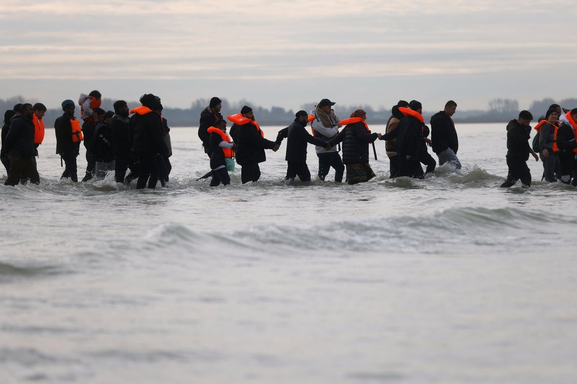 Migranter, som sædvanlig hovedsageligt voksne mænd, vader ud i vandet for at gå ombord på en lille båd i et forsøg på at nå Storbritannien ulovligt, november 2025 i Gravelines, Nordfrankrig. Foto: AP/Jean-Francois Badias/NTB Migranter, som sædvanlig hovedsageligt voksne mænd, vader ud i vandet for at gå ombord på en lille båd i et forsøg på at nå Storbritannien ulovligt, november 2025 i Gravelines, Nordfrankrig. Foto: AP/Jean-Francois Badias/NTB