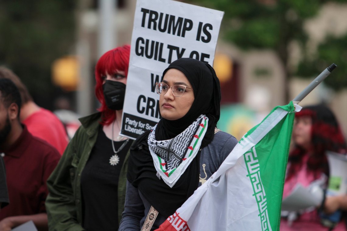 Zainab Haider holds a flag during a protest against the Iran war on Wednesday, April 8, 2026, in Austin, Texas. (Brianna Griffith via AP) Zainab Haider holds a flag during a protest against the Iran war on Wednesday, April 8, 2026, in Austin, Texas. (Brianna Griffith via AP)