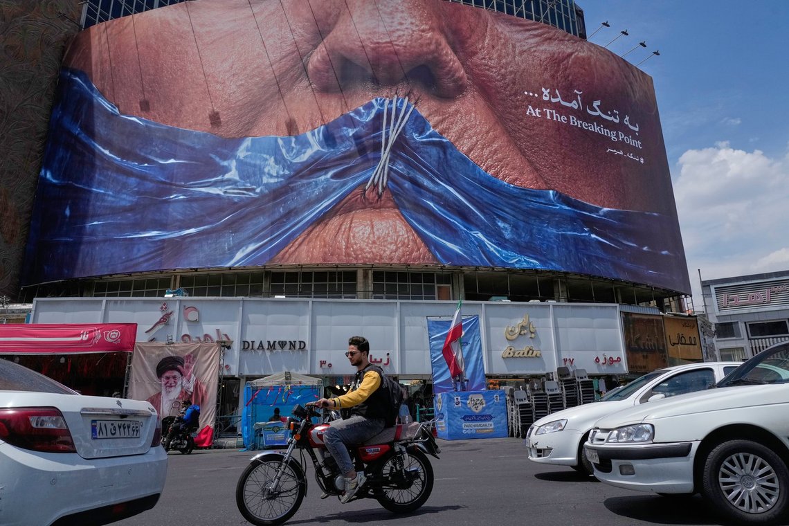 Vehicles drive past a billboard with graphic showing Strait of Hormuz and sewn lips of U.S. President Donald Trump in a square in downtown Tehran, Iran, Saturday, May 2, 2026. (AP Photo/Vahid Salemi) Vehicles drive past a billboard with graphic showing Strait of Hormuz and sewn lips of U.S. President Donald Trump in a square in downtown Tehran, Iran, Saturday, May 2, 2026. (AP Photo/Vahid Salemi)