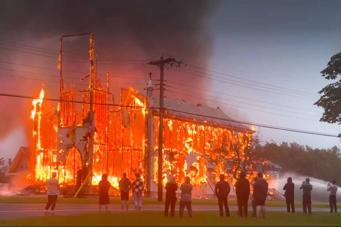 Den største bevarede trækirke i New Brunswick, »landsbyens sidste stolthed«, Église Saint-Simon, blev sat i brand natten til mandag. Videoklip fra YouTube Den største bevarede trækirke i New Brunswick, »landsbyens sidste stolthed«, Église Saint-Simon, blev sat i brand natten til mandag. Videoklip fra YouTube