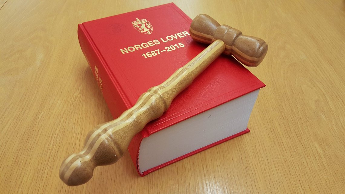 A gavel, the Laws of Norway, and the Norwegian coat of arms. A gavel, the Laws of Norway, and the Norwegian coat of arms.