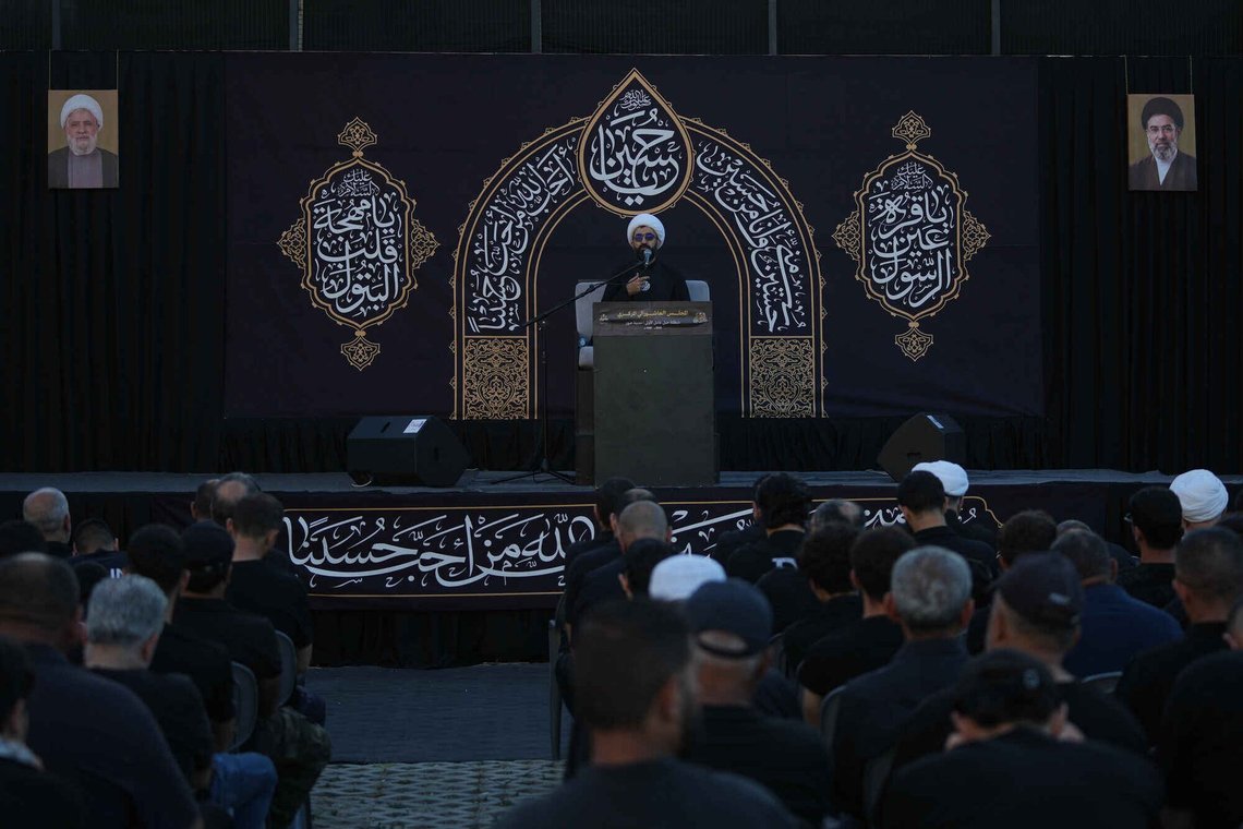 Portraits of Hezbollah leader Sheikh Naim Qassem, left, and Iran's Supreme Leader Mojtaba Khamenei, right, are displayed as Shiite cleric Abbas Al Shami delivers a sermon marking the third day of Ashoura, the Shiite Muslim commemoration of the 7th-century death of Imam Hussein, the grandson of the Prophet Muhammad, in the southern port city of Tyre, Lebanon, Friday, June 19, 2026. Portraits of Hezbollah leader Sheikh Naim Qassem, left, and Iran's Supreme Leader Mojtaba Khamenei, right, are displayed as Shiite cleric Abbas Al Shami delivers a sermon marking the third day of Ashoura, the Shiite Muslim commemoration of the 7th-century death of Imam Hussein, the grandson of the Prophet Muhammad, in the southern port city of Tyre, Lebanon, Friday, June 19, 2026.