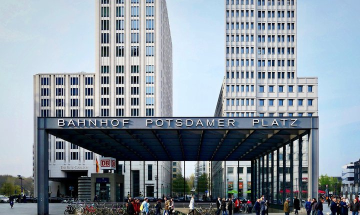 People walking beside modern office buildings at Potsdamer Platz in Berlin.