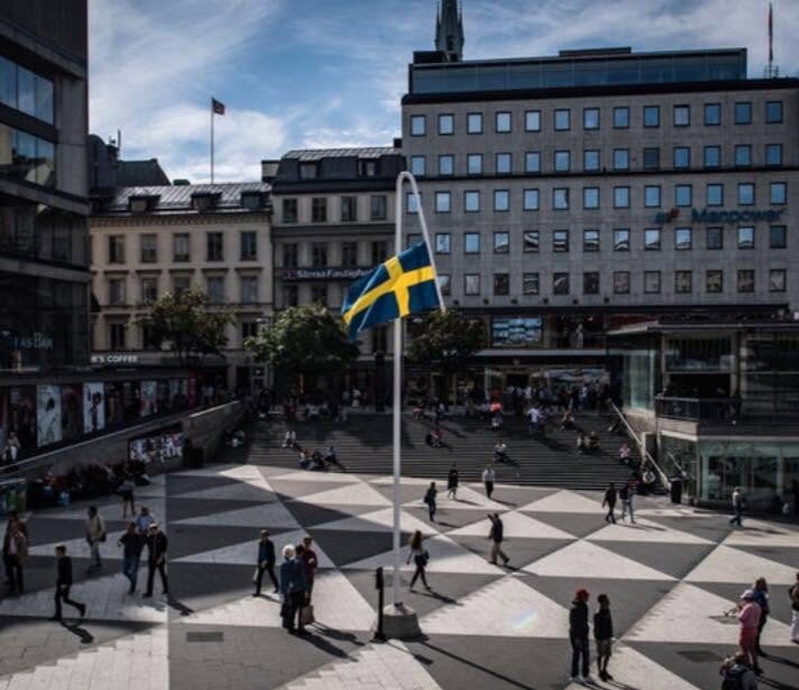 In 2017, a bent flagpole featuring an upside-down Swedish flag—the signal for an emergency—was placed in Sergels Torg in Stockholm. Photo: Facebook screenshot. In 2017, a bent flagpole featuring an upside-down Swedish flag—the signal for an emergency—was placed in Sergels Torg in Stockholm. Photo: Facebook screenshot.
