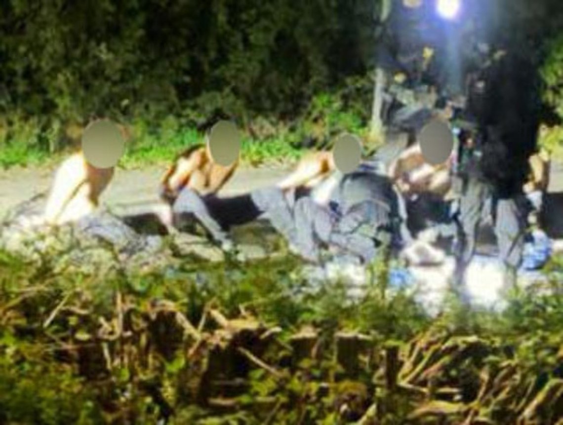Five men sit bare-chested after being arrested by police on Sunday. Screenshot: Daily Mail. Five men sit bare-chested after being arrested by police on Sunday. Screenshot: Daily Mail.