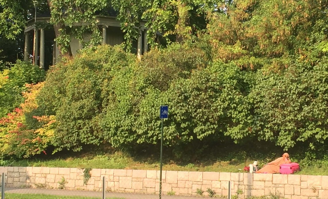 Oslo, 14 September 2016. Amid the ongoing ‘migration wave’, and before becoming familiar with the basics of Scandinavian society, a woman has settled down to wait beside a bus stop on the edge of Oslo’s ornamental Vigeland Park, much as one might do in the Horn of Africa, where buses do not materialise according to a timetable. Photo: Christian Borchsenius Oslo, 14 September 2016. Amid the ongoing ‘migration wave’, and before becoming familiar with the basics of Scandinavian society, a woman has settled down to wait beside a bus stop on the edge of Oslo’s ornamental Vigeland Park, much as one might do in the Horn of Africa, where buses do not materialise according to a timetable. Photo: Christian Borchsenius