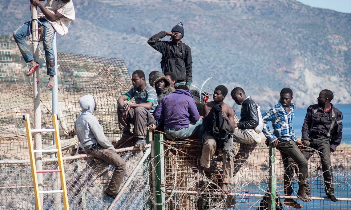 African migrants sit on top of a border fence covered in razor wire between Morocco and Spain's north African enclave of Melilla during their latest attempt to cross into Spanish territory, April 3, 2014. Spain has more than doubled the strength of security forces at Melilla, after about 500 people stormed its fences in the biggest border rush for years earlier this month. Immigrants from all over Africa regularly dare the razor-wire fences of Spanish enclaves Ceuta and Melilla, which are surrounded by Moroccan territory and sea. REUTERS/Jesus Blasco de Avellaneda (SPAIN - Tags: POLITICS SOCIETY IMMIGRATION) African migrants sit on top of a border fence covered in razor wire between Morocco and Spain's north African enclave of Melilla during their latest attempt to cross into Spanish territory, April 3, 2014. Spain has more than doubled the strength of security forces at Melilla, after about 500 people stormed its fences in the biggest border rush for years earlier this month. Immigrants from all over Africa regularly dare the razor-wire fences of Spanish enclaves Ceuta and Melilla, which are surrounded by Moroccan territory and sea. REUTERS/Jesus Blasco de Avellaneda (SPAIN - Tags: POLITICS SOCIETY IMMIGRATION)