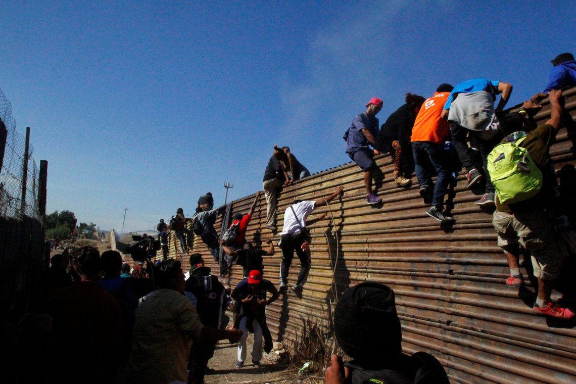 Migrants climb the border fence between Mexico and the United States in an attempt to cross into the U.S side of the border in Tijuana, Mexico, November 25, 2018. REUTERS/Jorge Duenes Migrants climb the border fence between Mexico and the United States in an attempt to cross into the U.S side of the border in Tijuana, Mexico, November 25, 2018. REUTERS/Jorge Duenes