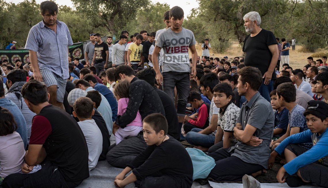 Shiite Muslims from Afghanistan attend a mourning ritual days before Ashura at Moria camp on the Greek island of Lesbos, in the northern Aegean Sea, Aug. 9, 2019. August was the busiest month in more than three years for migrants making their way across the Aegean Sea to Greece — the surge comes as President Recep Tayyip Erdogan of Turkey threatens to allow high numbers of migrants to make their way through the country to Greece, should European politicians fail to agree to his terms. (Laura Boushnak/The New York Times) Shiite Muslims from Afghanistan attend a mourning ritual days before Ashura at Moria camp on the Greek island of Lesbos, in the northern Aegean Sea, Aug. 9, 2019. August was the busiest month in more than three years for migrants making their way across the Aegean Sea to Greece — the surge comes as President Recep Tayyip Erdogan of Turkey threatens to allow high numbers of migrants to make their way through the country to Greece, should European politicians fail to agree to his terms. (Laura Boushnak/The New York Times)