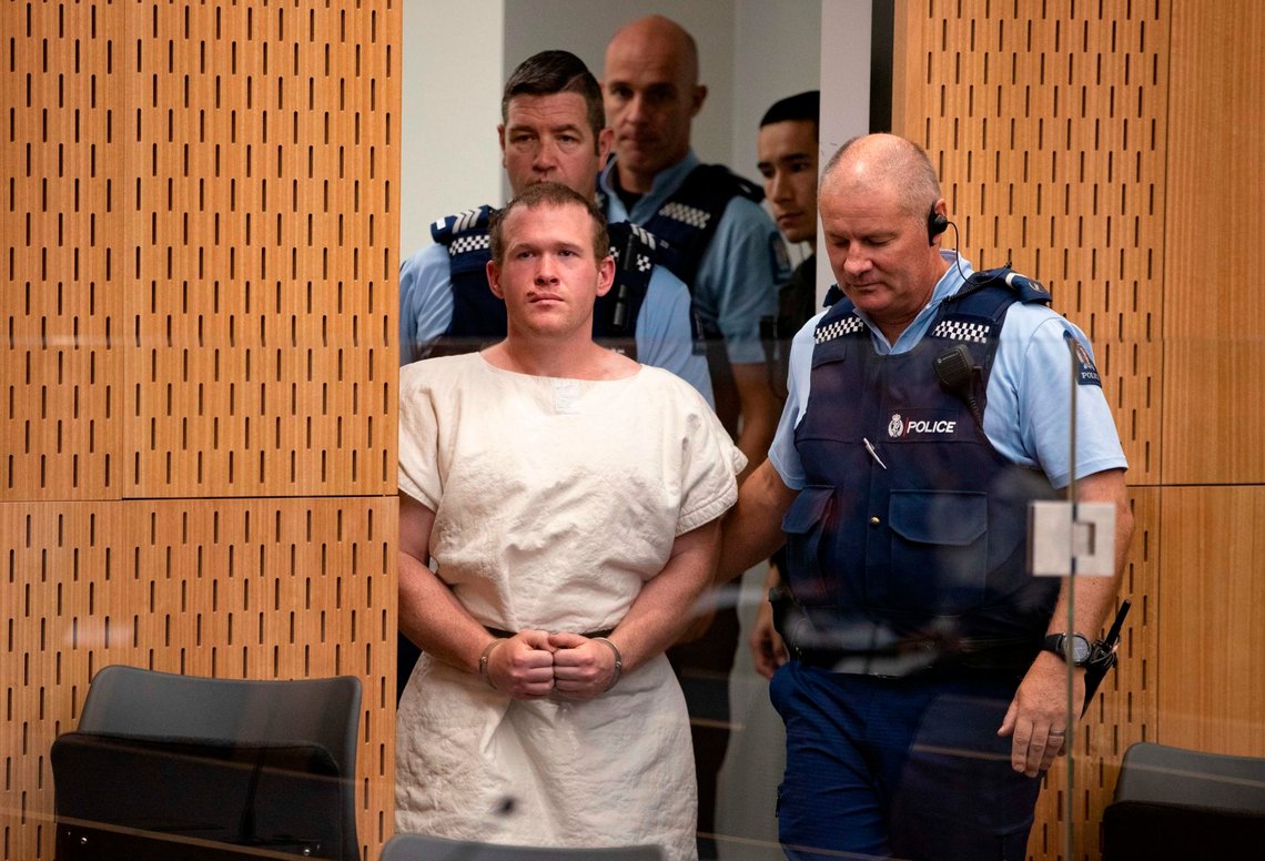 In this picture taken on March 16, 2019, Brenton Tarrant (C), the man charged in relation to the Christchurch massacre, is escorted to the dock during his appearance at the Christchurch District Court. - The man accused of shooting dead 51 Muslim worshippers in the Christchurch mosque attacks pleaded not guilty to multiple murder and terrorism charges on June 14, 2019 and was committed to stand trial next year. (Photo by Mark Mitchell / POOL / AFP) In this picture taken on March 16, 2019, Brenton Tarrant (C), the man charged in relation to the Christchurch massacre, is escorted to the dock during his appearance at the Christchurch District Court. - The man accused of shooting dead 51 Muslim worshippers in the Christchurch mosque attacks pleaded not guilty to multiple murder and terrorism charges on June 14, 2019 and was committed to stand trial next year. (Photo by Mark Mitchell / POOL / AFP)