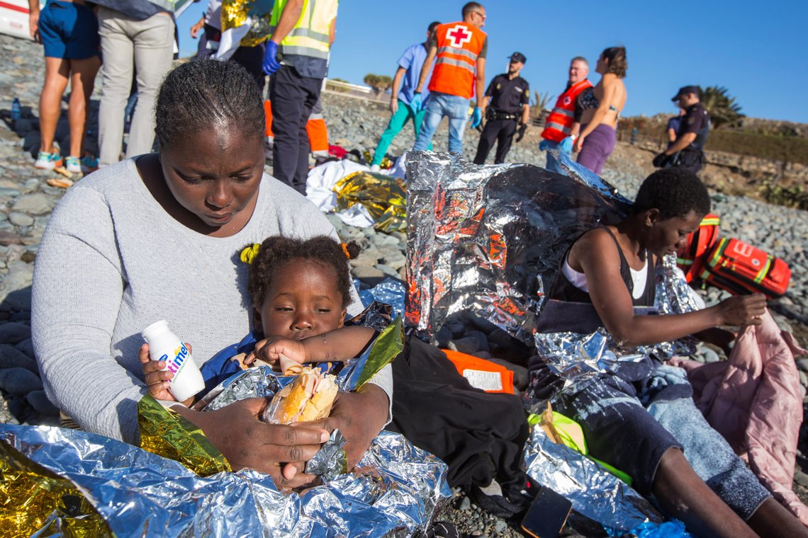 A migrant sits with her child after a group landed in a dinghy at Aguila beach on the island of Las Palmas de Gran Canaria, Spain November 29, 2019. REUTERS/Borja Suarez A migrant sits with her child after a group landed in a dinghy at Aguila beach on the island of Las Palmas de Gran Canaria, Spain November 29, 2019. REUTERS/Borja Suarez