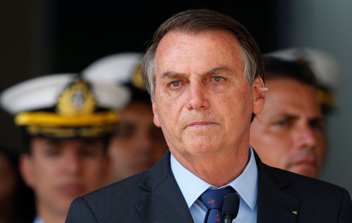 With a band aid on his ear, Brazil's President Jair Bolsonaro attends a military ceremony in honor of Sailor Day, in Brasilia, Brazil, Friday, Dec. 13, 2019. Bolsonaro said to the press on Wednesday, Dec. 11, that he has a possible skin cancer after he had a mole removed from his ear. (AP Photo /Eraldo Peres) With a band aid on his ear, Brazil's President Jair Bolsonaro attends a military ceremony in honor of Sailor Day, in Brasilia, Brazil, Friday, Dec. 13, 2019. Bolsonaro said to the press on Wednesday, Dec. 11, that he has a possible skin cancer after he had a mole removed from his ear. (AP Photo /Eraldo Peres)
