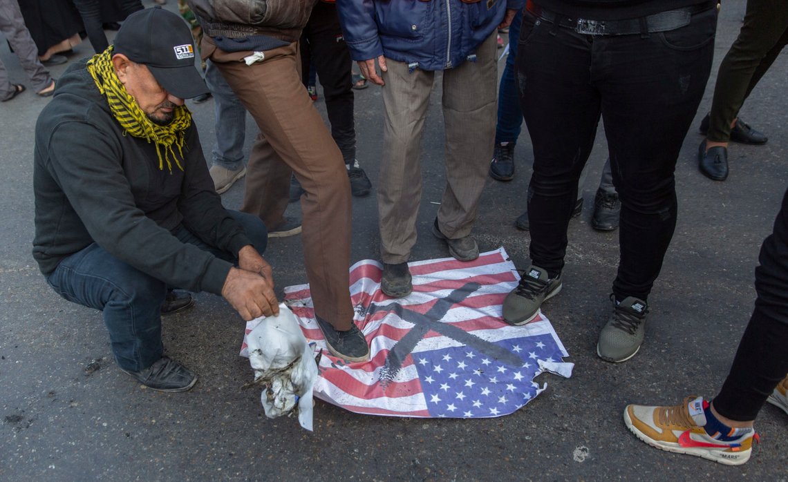 Mourners step over a U.S. flags before burning it during the funeral of Iran's top general Qassem Soleimani and Abu Mahdi al-Muhandis, deputy commander of Iran-backed militias in Iraq known as the Popular Mobilization Forces, in Baghdad, Iraq, Saturday, Jan. 4, 2020. Thousands of mourners chanting "America is the Great Satan" marched in a funeral procession Saturday through Baghdad for Iran's top general and Iraqi militant leaders, who were killed in a U.S. airstrike. (AP Photo/Nasser Nasser) Mourners step over a U.S. flags before burning it during the funeral of Iran's top general Qassem Soleimani and Abu Mahdi al-Muhandis, deputy commander of Iran-backed militias in Iraq known as the Popular Mobilization Forces, in Baghdad, Iraq, Saturday, Jan. 4, 2020. Thousands of mourners chanting "America is the Great Satan" marched in a funeral procession Saturday through Baghdad for Iran's top general and Iraqi militant leaders, who were killed in a U.S. airstrike. (AP Photo/Nasser Nasser)