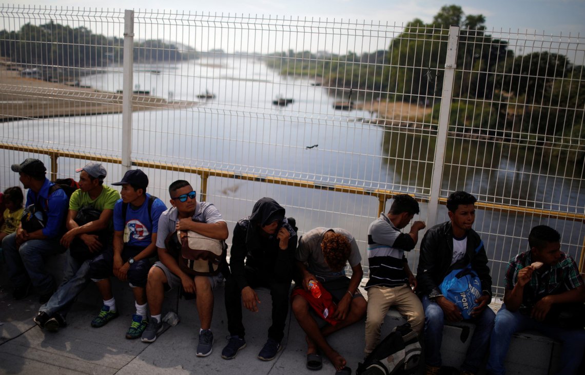 Migrants travelling to the U.S. sit at the border bridge between Guatemala and Mexico, in Tecun Uman, Guatemala, January 18, 2020. REUTERS/Jose Cabezas Migrants travelling to the U.S. sit at the border bridge between Guatemala and Mexico, in Tecun Uman, Guatemala, January 18, 2020. REUTERS/Jose Cabezas