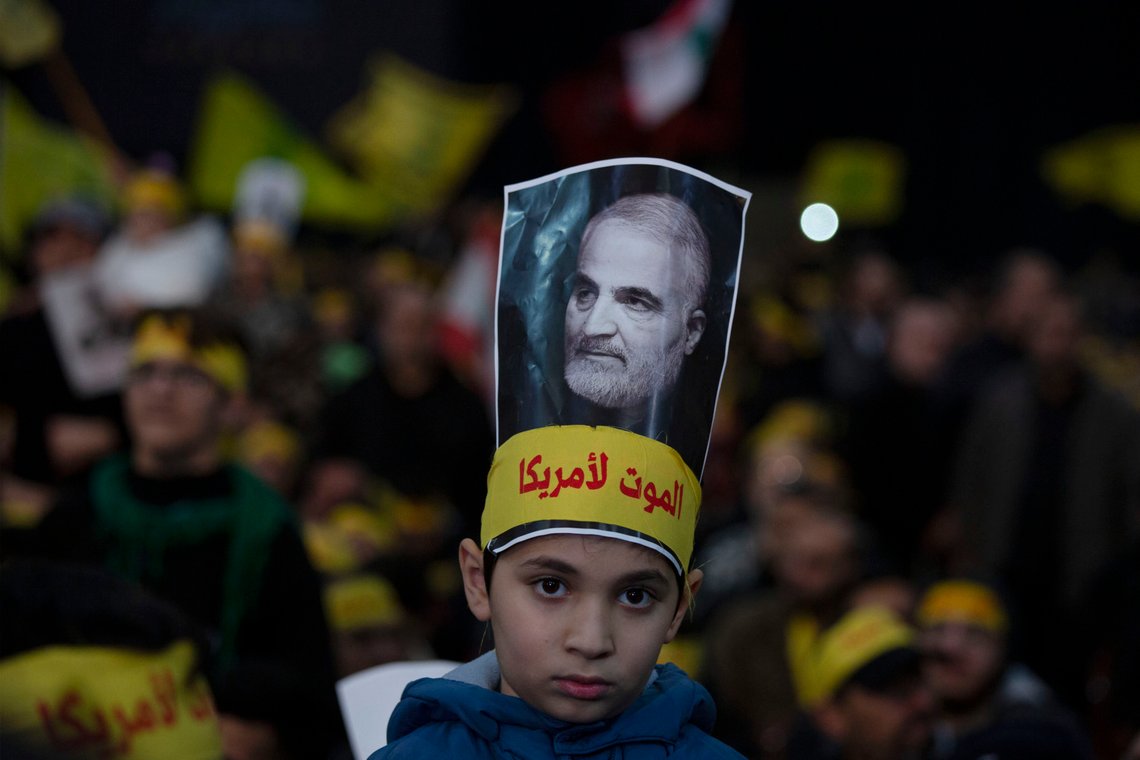A child wears a picture of slain Iranian Revolutionary Guard Gen. Qassem Soleimani as supporters of Hezbollah leader Sayyed Hassan Nasrallah gather for his televised speech in a southern suburb of Beirut, Lebanon, Sunday, Jan. 5, 2020 following the U.S. airstrike in Iraq that killed Soleimani. The headband reads, "death to America." (AP Photo/Maya Alleruzzo) A child wears a picture of slain Iranian Revolutionary Guard Gen. Qassem Soleimani as supporters of Hezbollah leader Sayyed Hassan Nasrallah gather for his televised speech in a southern suburb of Beirut, Lebanon, Sunday, Jan. 5, 2020 following the U.S. airstrike in Iraq that killed Soleimani. The headband reads, "death to America." (AP Photo/Maya Alleruzzo)