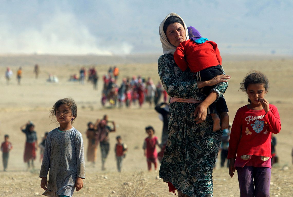 FILE PHOTO: Displaced people from the minority Yazidi sect, fleeing violence from forces loyal to the Islamic State in Sinjar town, walk towards the Syrian border on the outskirts of Sinjar mountain near the Syrian border town of Elierbeh of Al-Hasakah Governorate in this August 11, 2014. REUTERS/Rodi Said/File Photo FILE PHOTO: Displaced people from the minority Yazidi sect, fleeing violence from forces loyal to the Islamic State in Sinjar town, walk towards the Syrian border on the outskirts of Sinjar mountain near the Syrian border town of Elierbeh of Al-Hasakah Governorate in this August 11, 2014. REUTERS/Rodi Said/File Photo