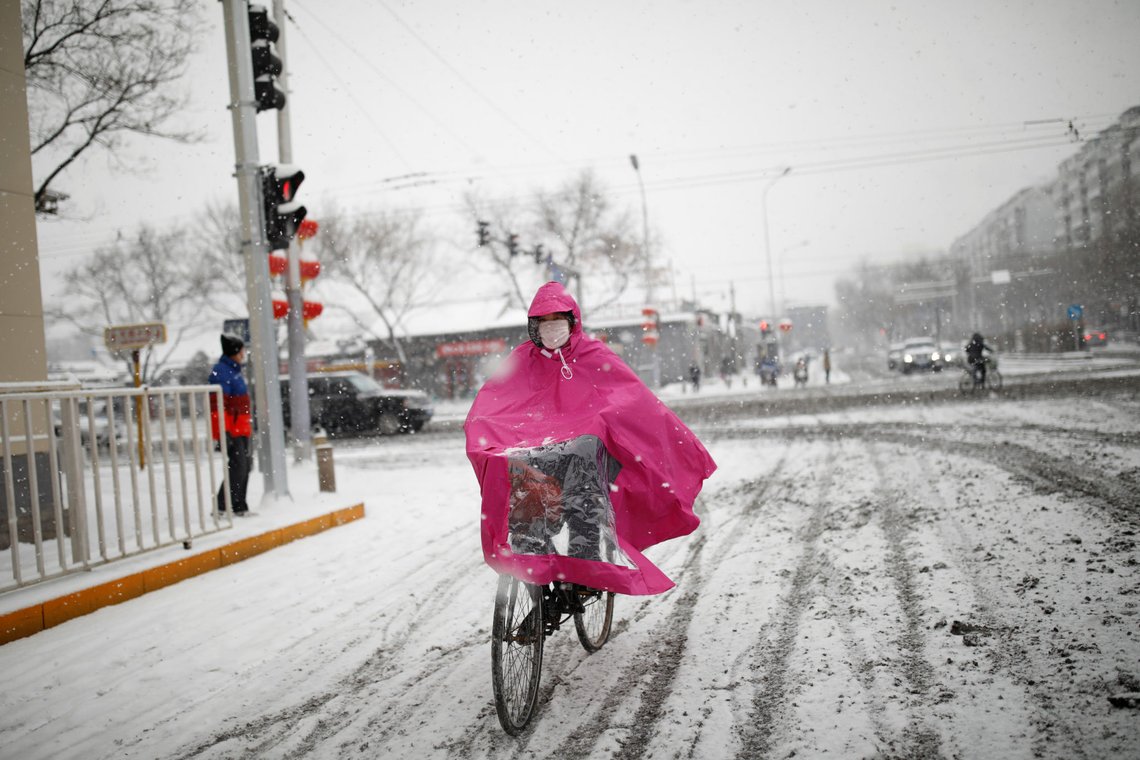 A woman wearing a face mask rides a bicycle amid snow, as the country is hit by an outbreak of the novel coronavirus, in Beijing, China February 6, 2020. REUTERS/Carlos Garcia Rawlins A woman wearing a face mask rides a bicycle amid snow, as the country is hit by an outbreak of the novel coronavirus, in Beijing, China February 6, 2020. REUTERS/Carlos Garcia Rawlins